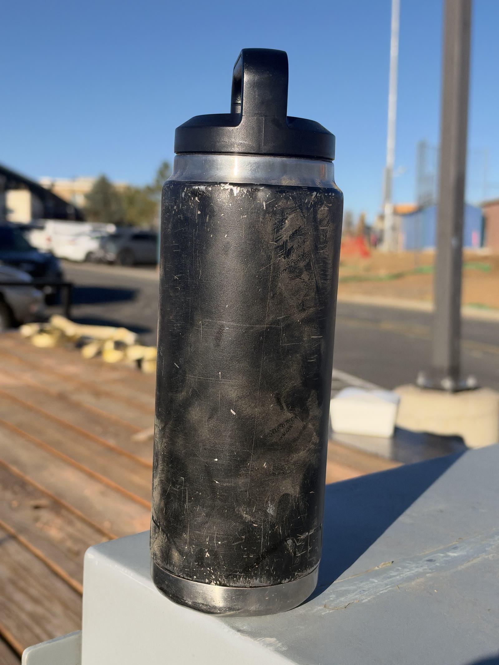Case 01: a well-used black job-site bottle with scuffed exterior, photographed as-is